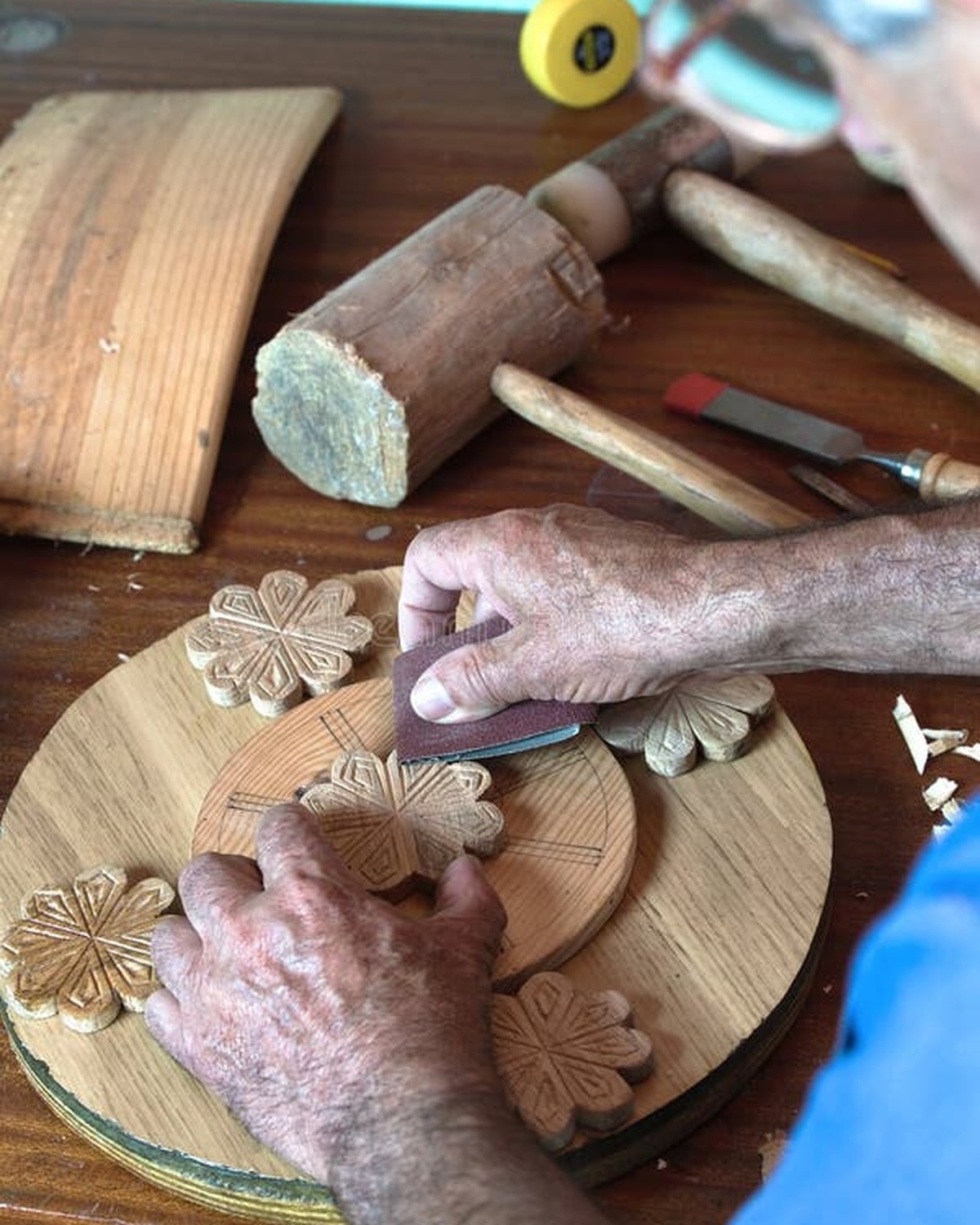 Woodworker's hands sanding a piece of walnut in the workshop